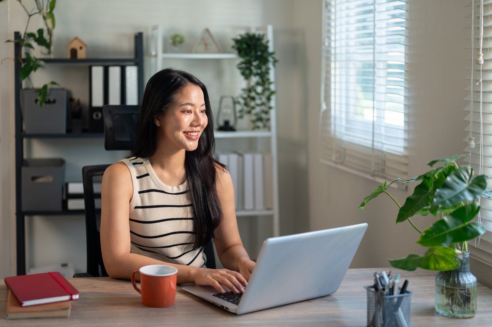 Professional working on a laptop in a bright home office